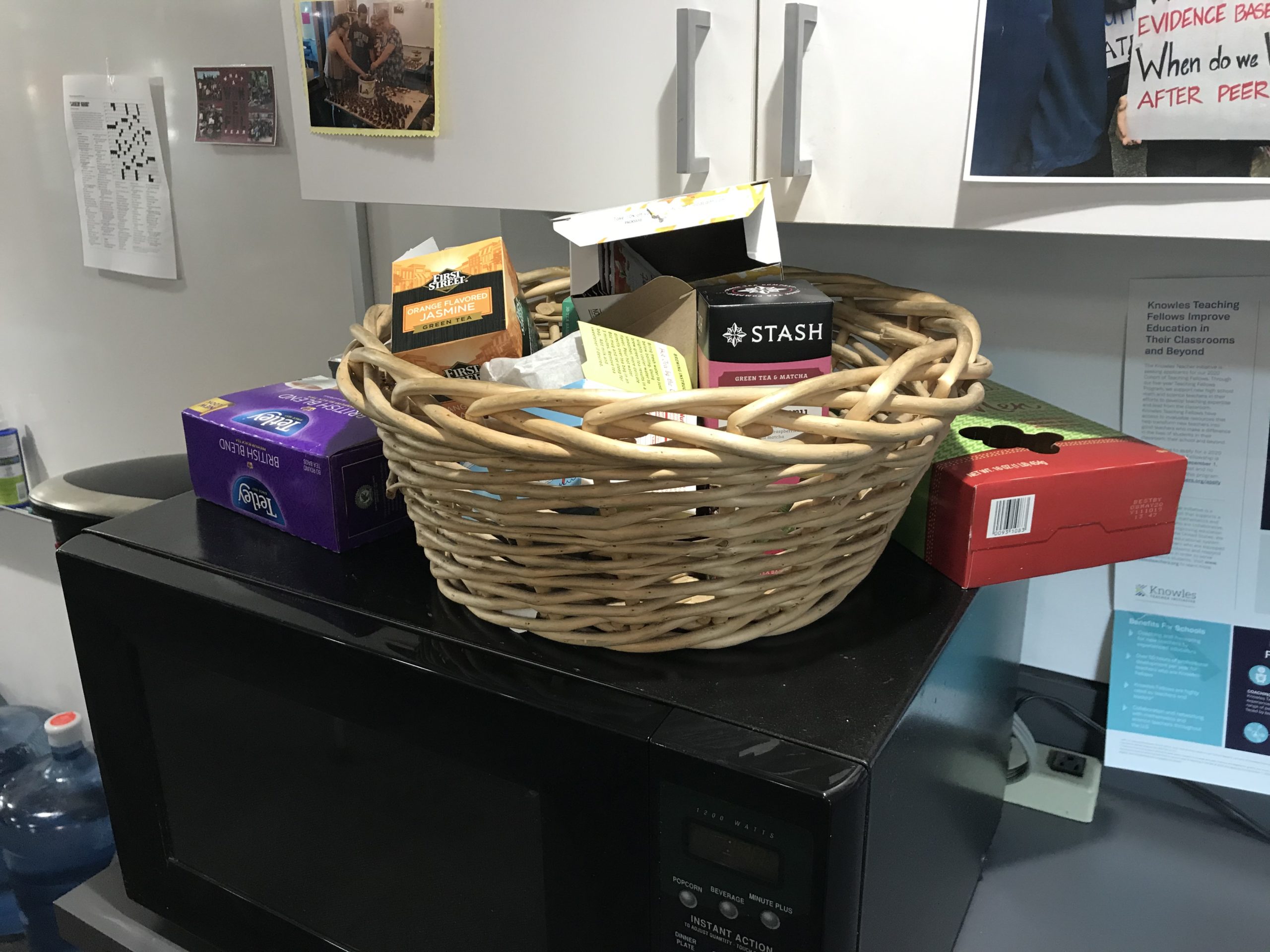 A wicker basket full of an assortment of boxed teas.