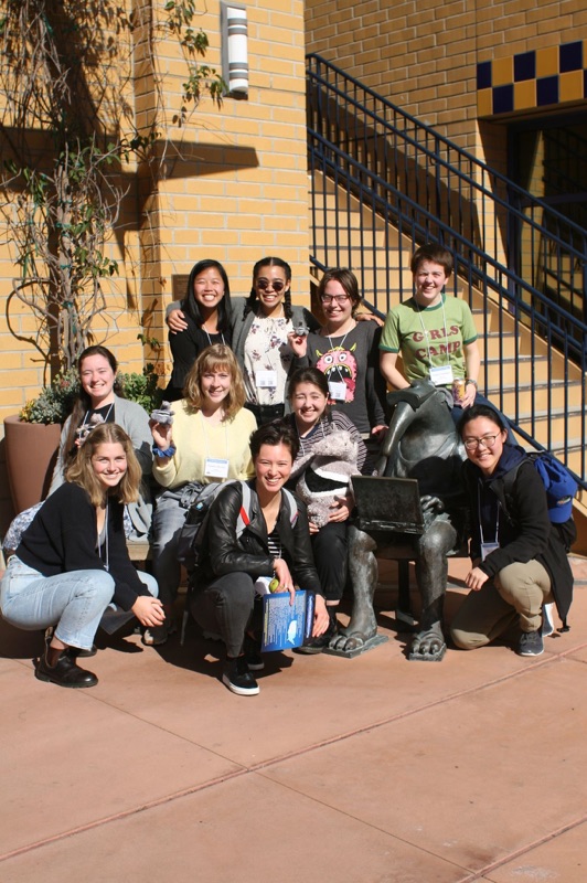 The ten of us sitting on a bench with an anteater statue