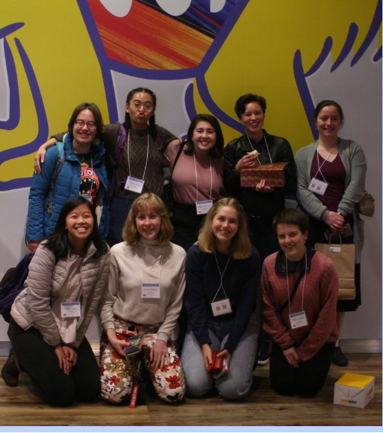 Nine people in front of the anteater mascot