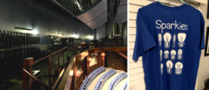 Left: The left side of the photo displays racks of lights hanging in storage while the right side of the photo is a view of the tops of chairs in the audience of the theatre. Right: Photo shows the back of a blue shirt with the word “Sparkies” at the top and different images of theater light bulbs.