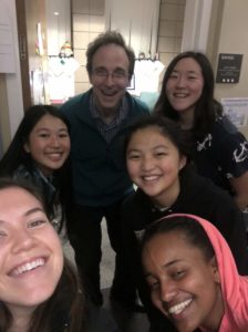 Prof. Dodds, Kailee, and four of her suitemates smile for a selfie outside his office.