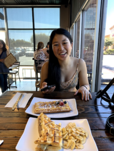 Me (Kailee) smiling with two waffles on the table in front of me.