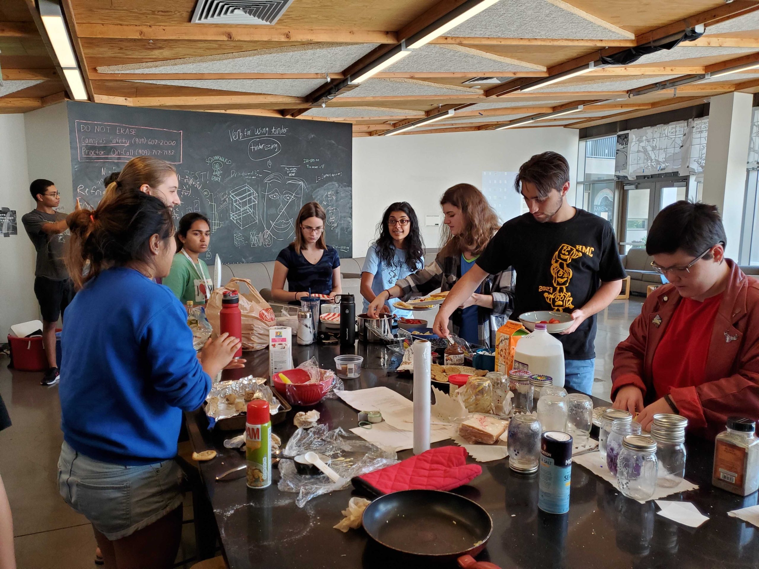 A group of students around a table with different crepe toppings.