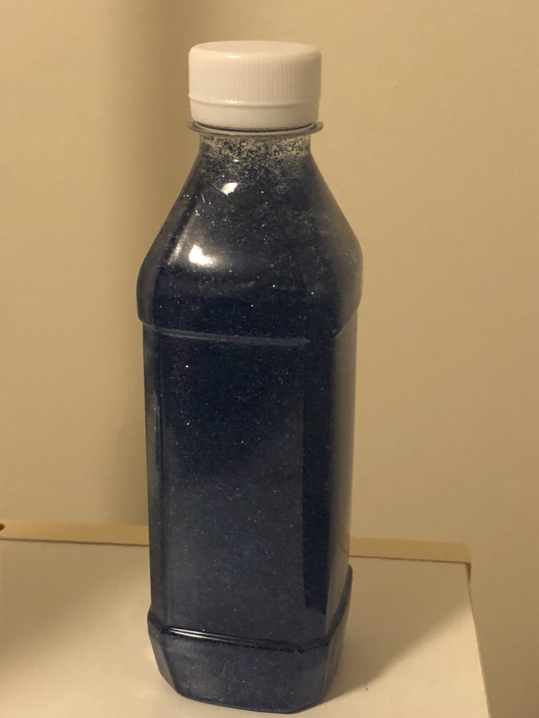 Plastic bottle with blue glitter inside.