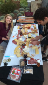 Members of Cheese Club pose with a cheese platter.