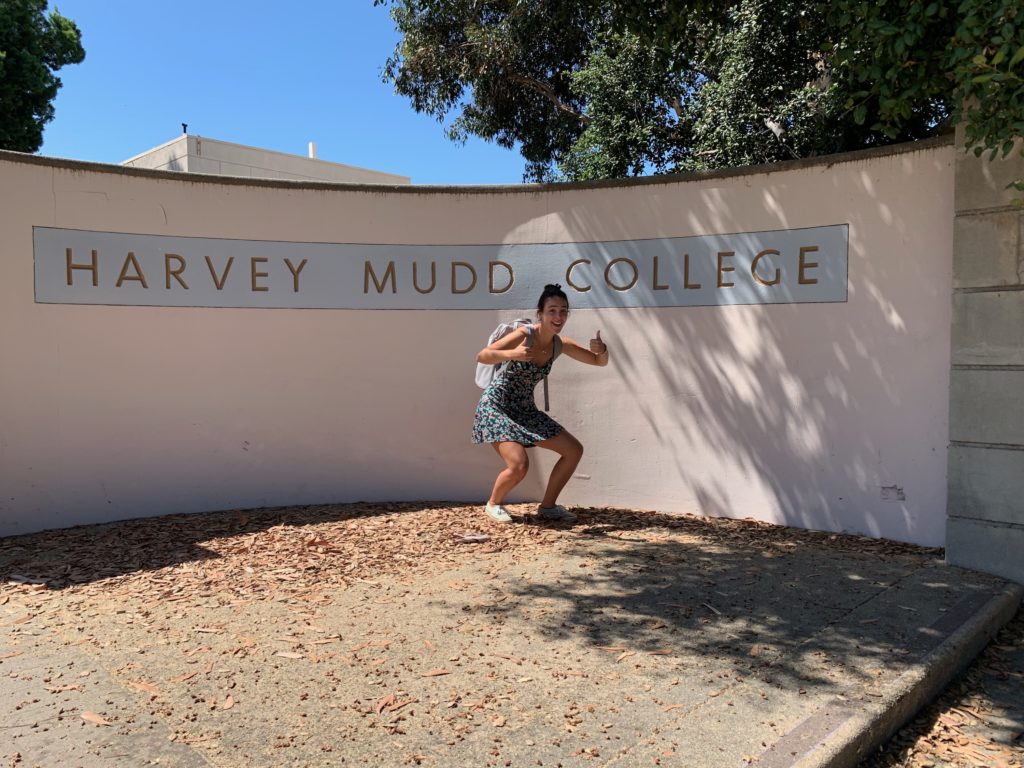Melis posing with the HMC sign