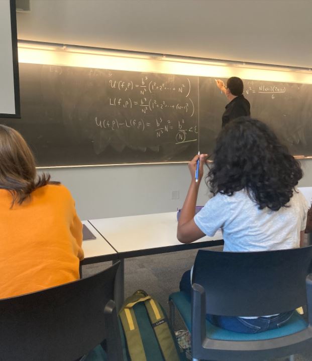 Professor writing on a chalkboard