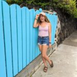 Mikayla in front of a blue fence