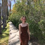 Laney standing on a path through trees