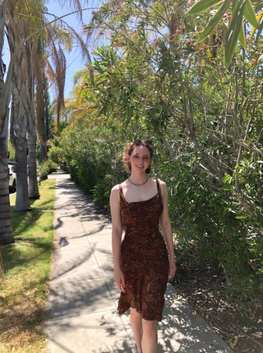 Laney standing on a path through trees