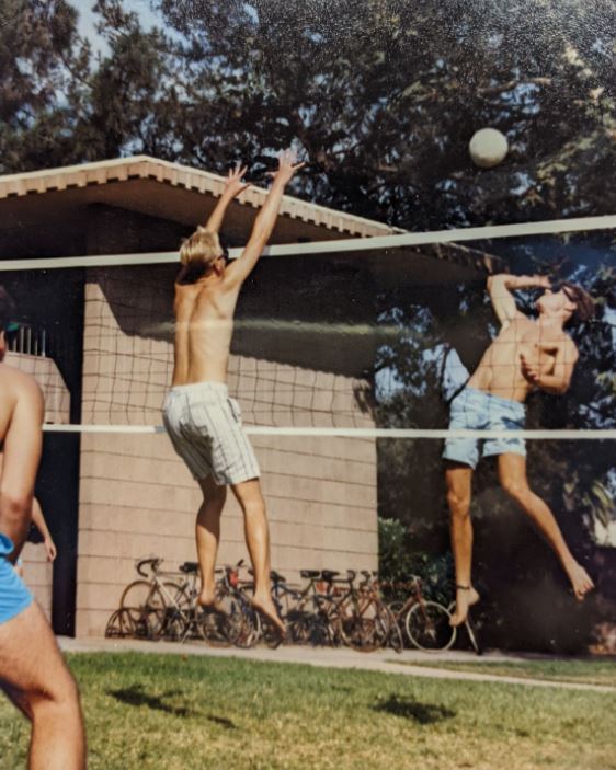 Three students playing volleyball over a net