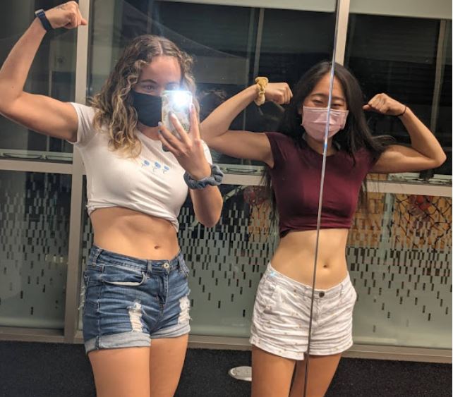 Two students flexing their arms