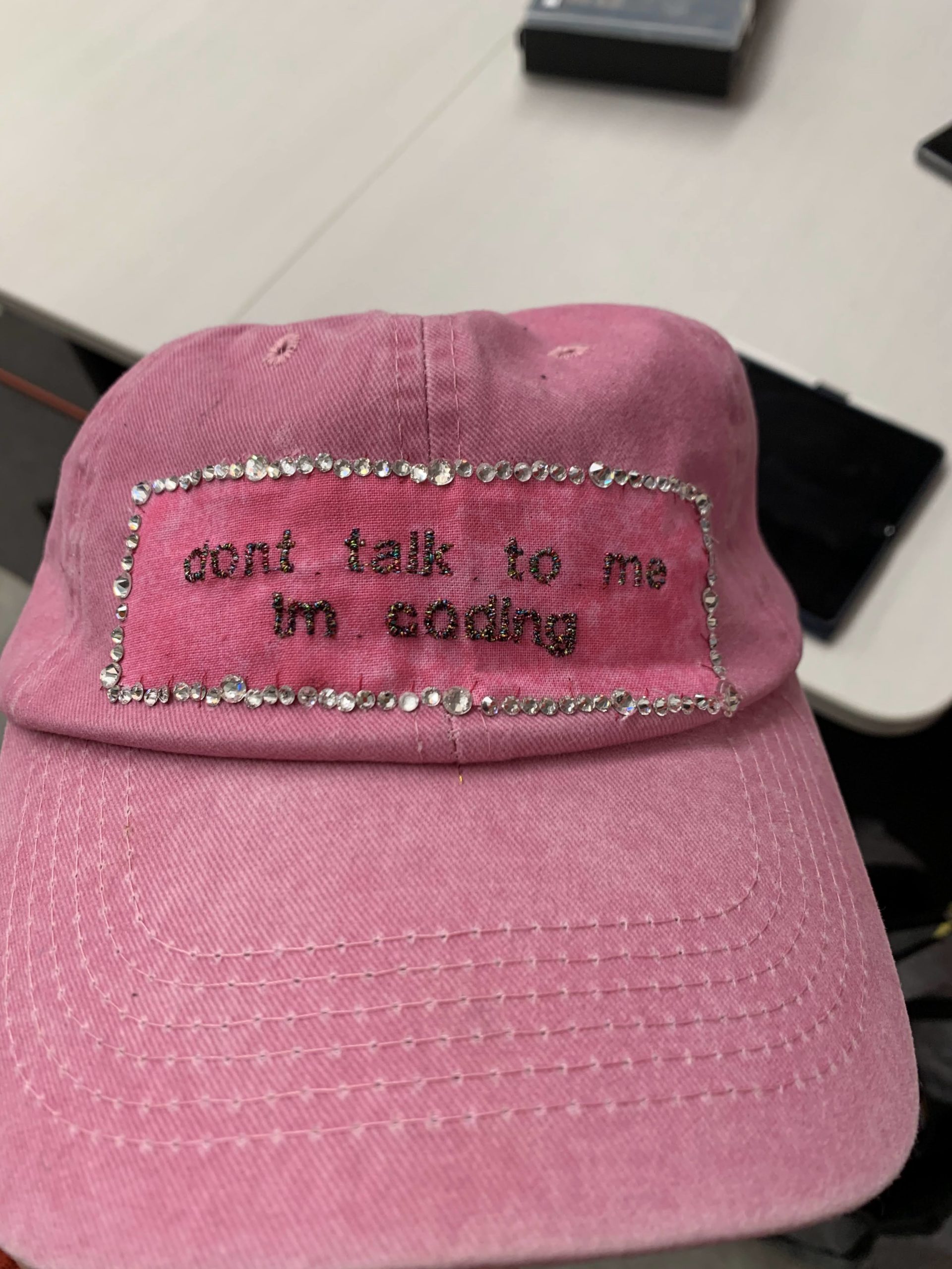 A pink hat reading "dont talk to me I'm coding"