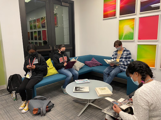 A group of students around a table, looking at books