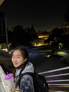 Student on building stairs at night.