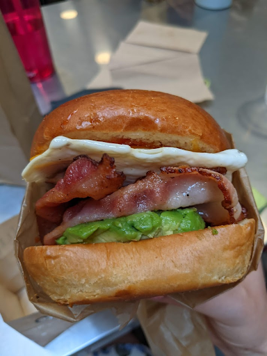 close up of bun with bacon and guacamole