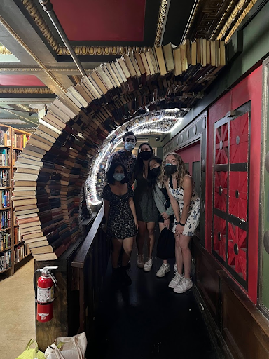 People crouched under an arch made form books