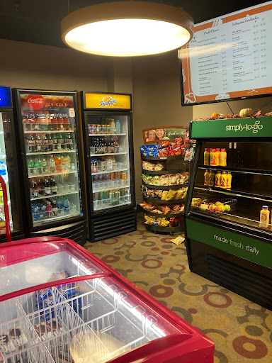 Photo of drinks coolers, sandwich refrigerator, and cabinet of chips