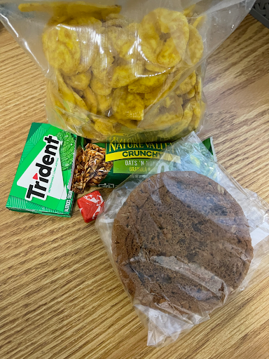 A photograph of banana chips, a granola bar, and other snacks
