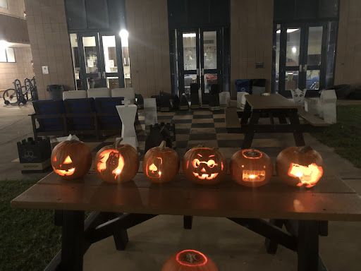 Six carved pumpkins glowing in the dark