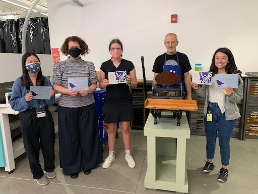 Students showing prints with skeletons and ravens