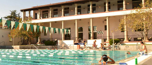 Swimming pool with columned building at rear.