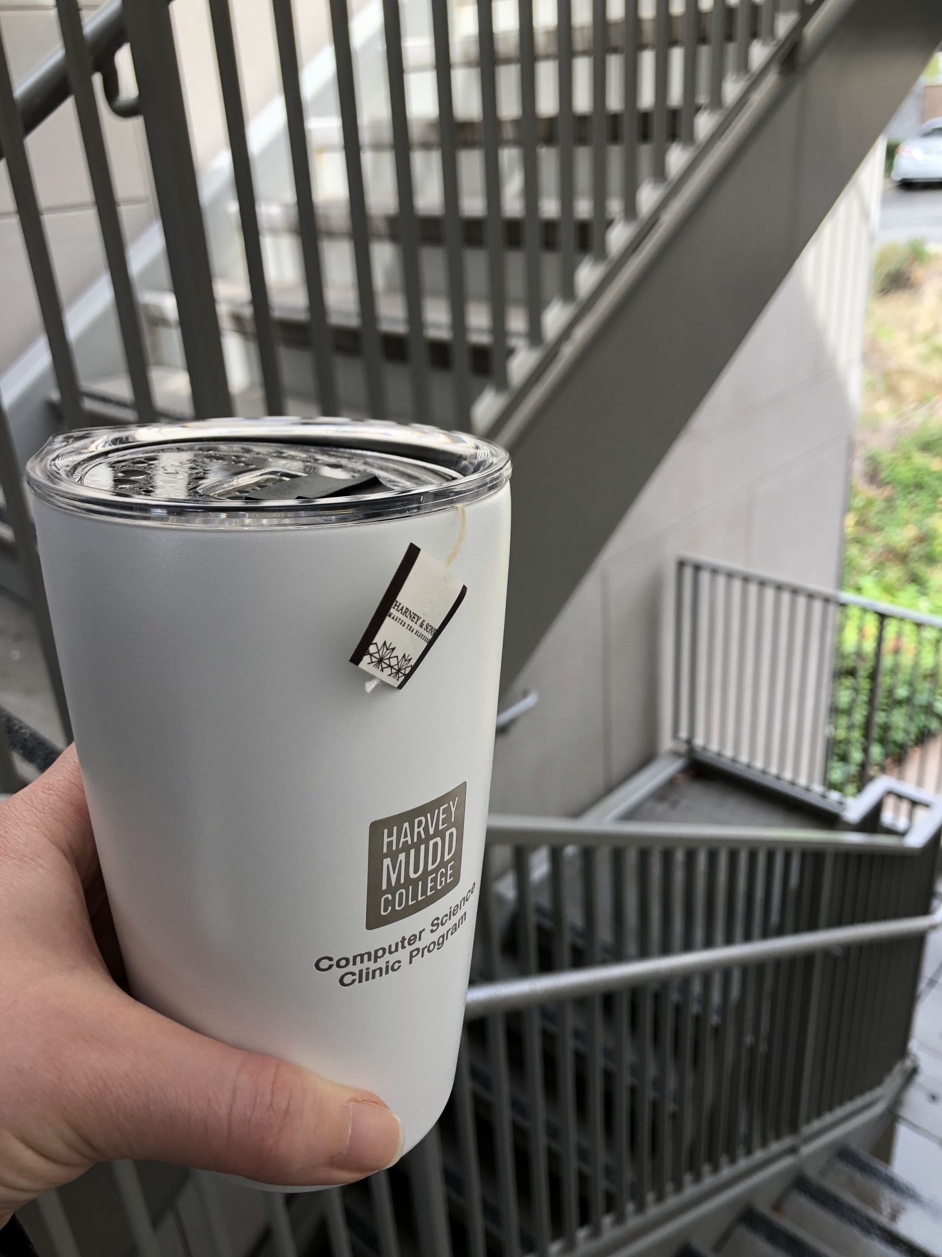 Hand holding thermos with print "Harvey Mudd College Computer Science Clinic Program"