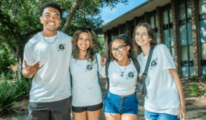 Four students posing in front of building