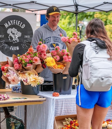 Montgomery talks to customer at flower stall