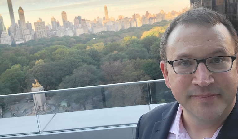Cope atop a building with city skyline in background