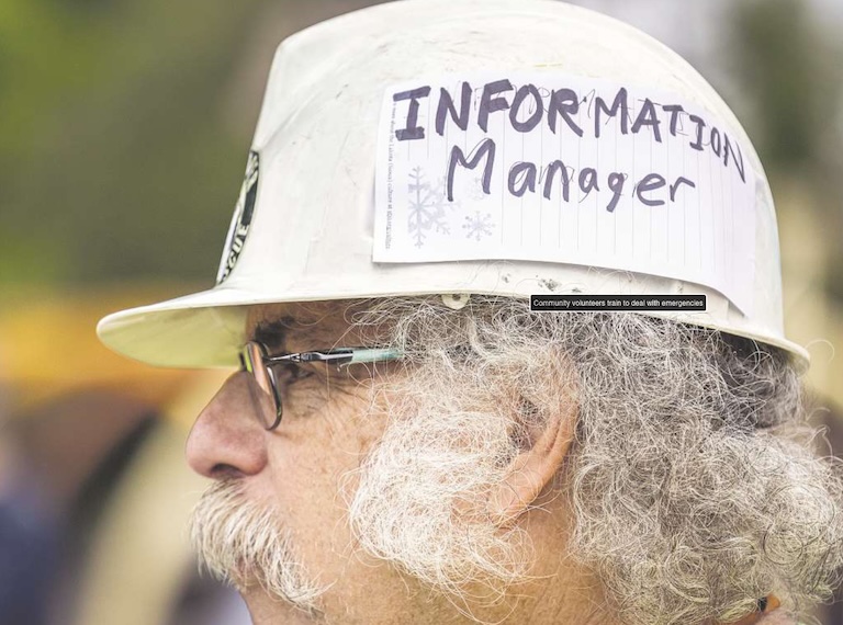 Close up of Jeff's head wearing cap with pinned note saying Information Manager