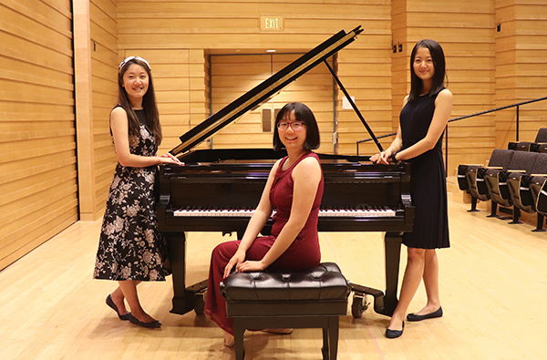 HMC seniors pose by piano: Haoxing Du, Nora Hu and Maggie Li