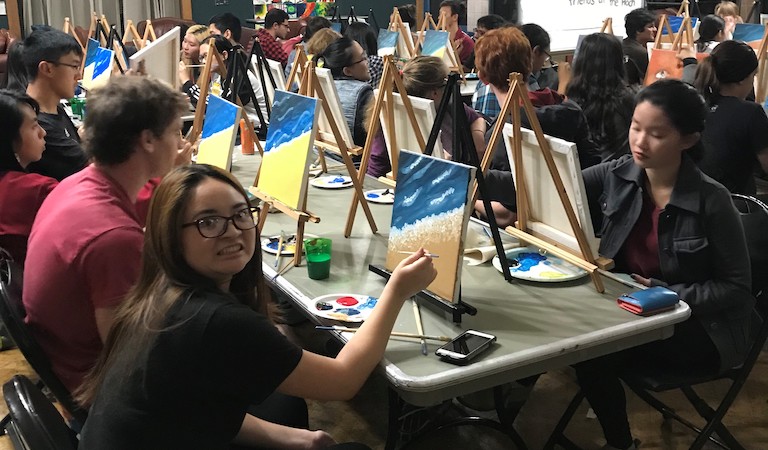 Painting at easels on table