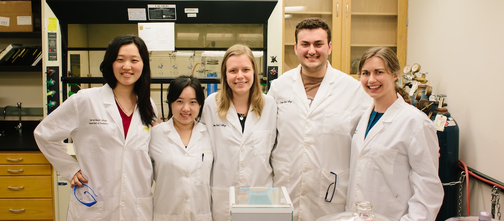 Prof Van Heuvelen and students pose in lab.