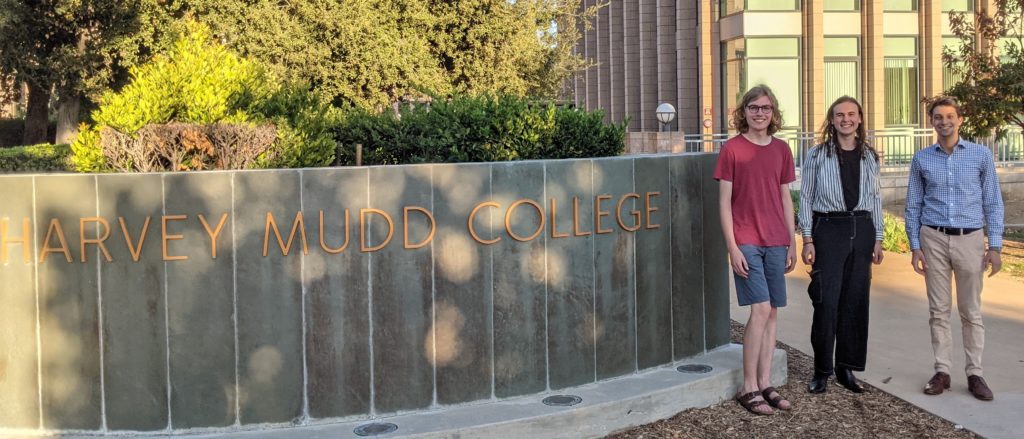 Ethan Flanagan, Joseph Sherby, Prof. Spencer Brucks next to Harvey Mudd College sign.