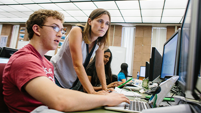 Julie Medero and student working on a computer. 