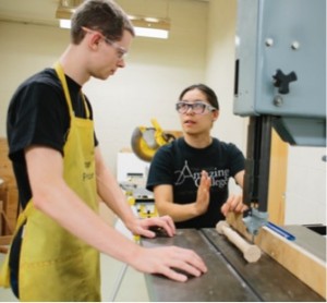 Two students discuss working on the saw