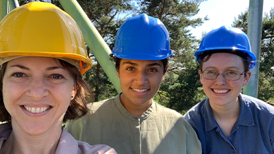 Lelia Hawkins and students wearing hard hats. 