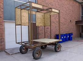 Steel framed cart with four wheels.