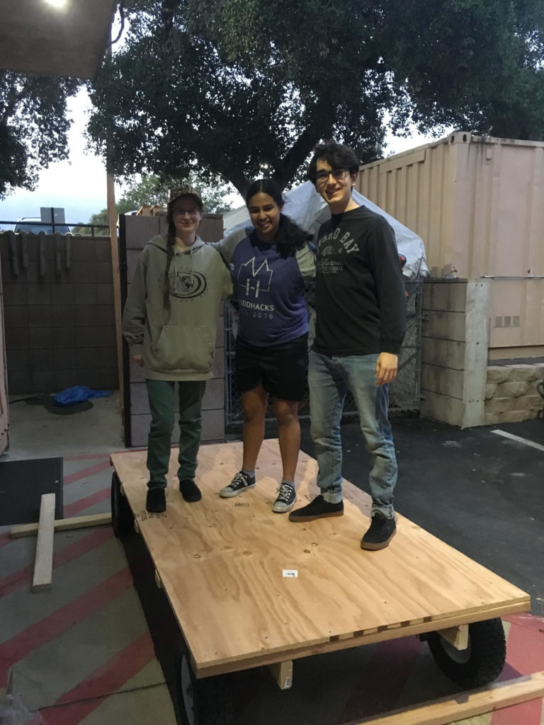 Three students on cart base.