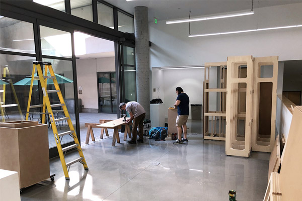 Workers build portable walls in Sprague Gallery, Harvey Mudd College