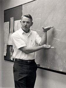 James Monson at blackboard, teaching