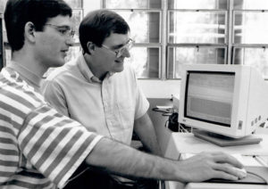 Bob Cave and student look at computer monitor