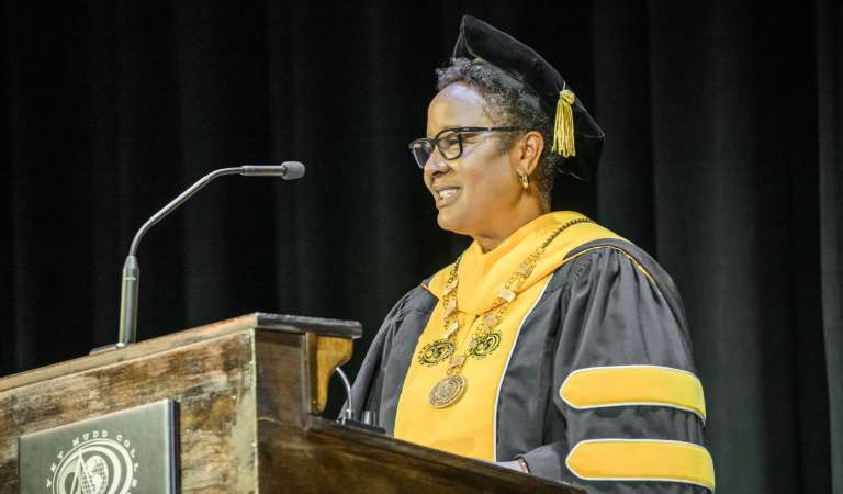 President Nembhard at podium dressed in academic regalia