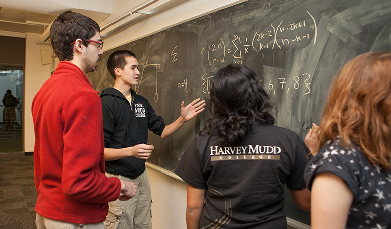 Students studying on a chalk board.