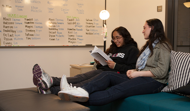 Students reading a book together in the Writing Center.