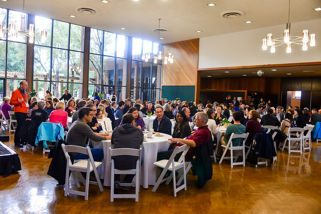 People sitting at tables in hall.
