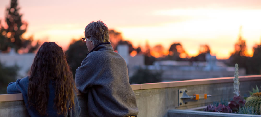 Parents enjoy a the sunset on the roof of the Shanahan Center