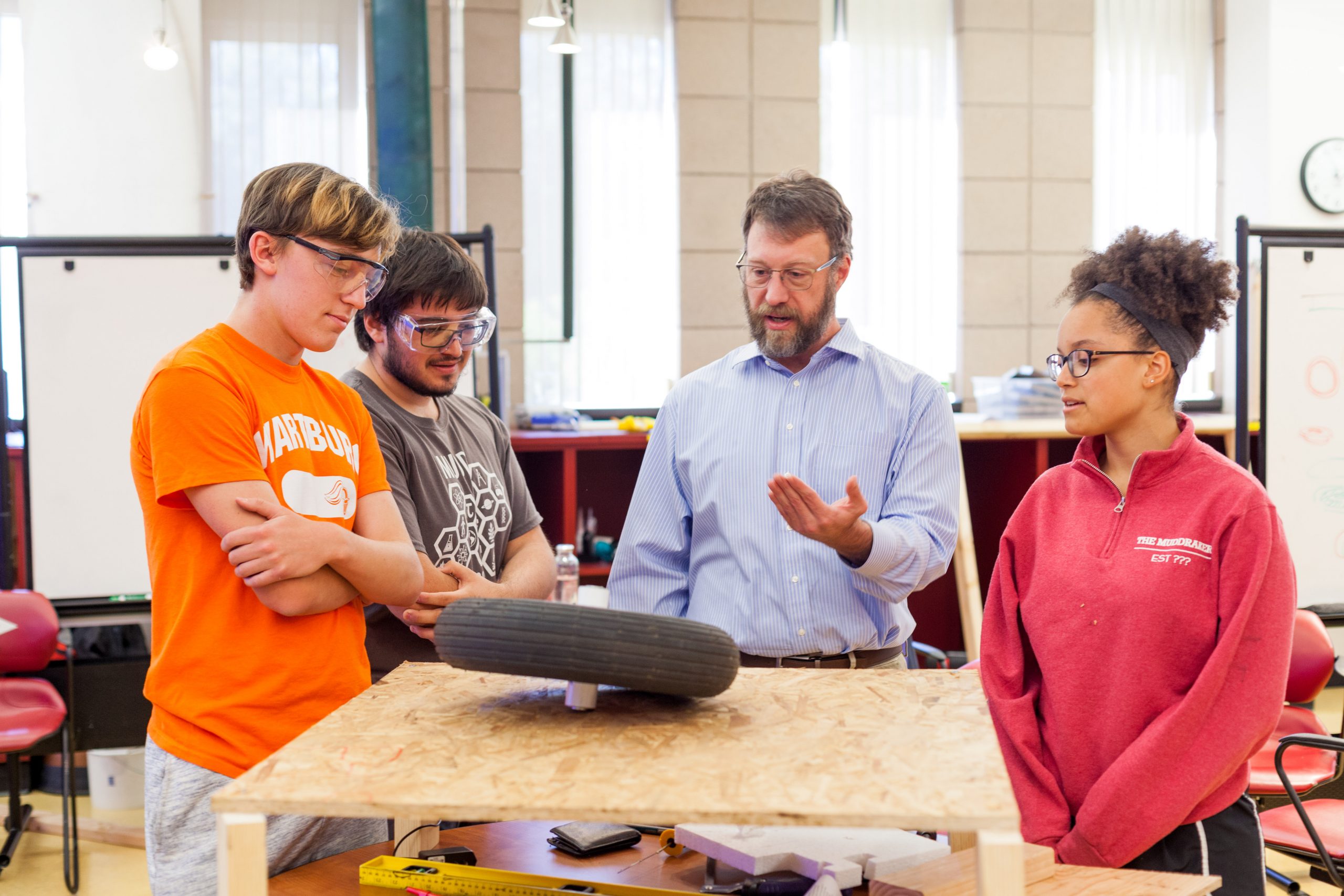 Students and professor at work bench