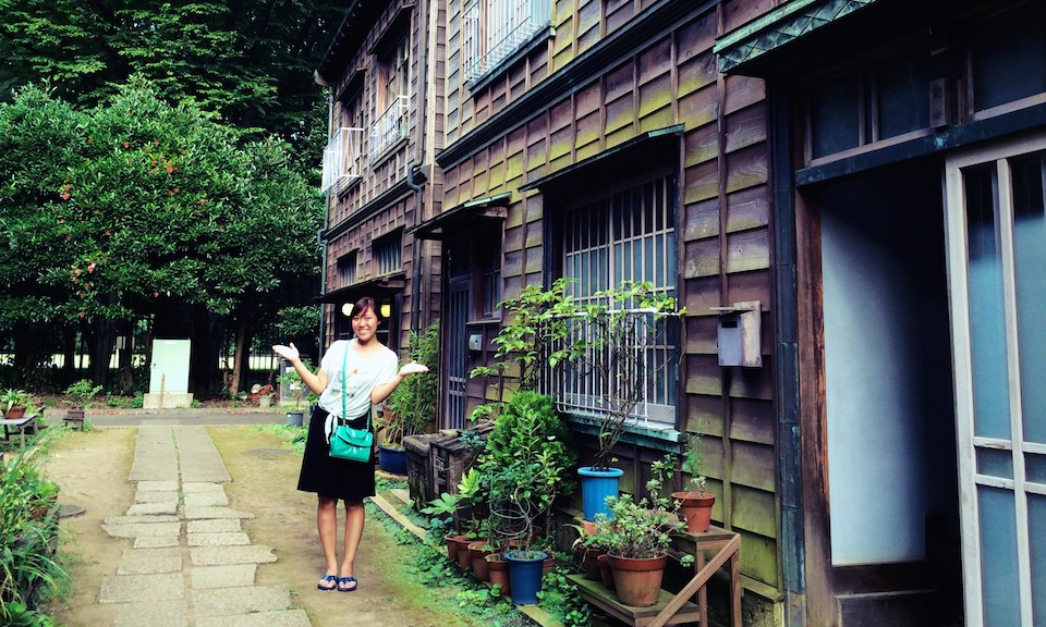 Student outside traditional wood clad house